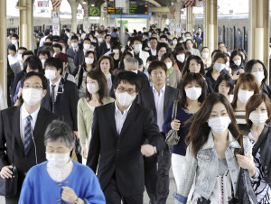 Commuters wear masks as precaution against swine flu at Sannomiya station, Kobe, western Japan, Tuesday, May 19, 2009. Japan confirmed 20 new swine flu cases overnight to brings its tally to more than 150, health officials said Tuesday, as the government considered scaling down quarantine checks at airports while focusing on its domestic outbreak. (AP Photo/Kyodo News) ** JAPAN OUT MANDATORY CREDIT FOR COMMERCIAL USE ONLY IN NORTH AMERICA **